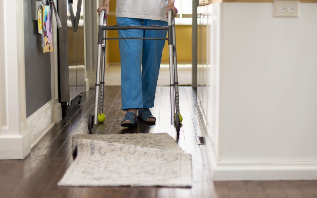 Person walking with walker approaches bunched rug.