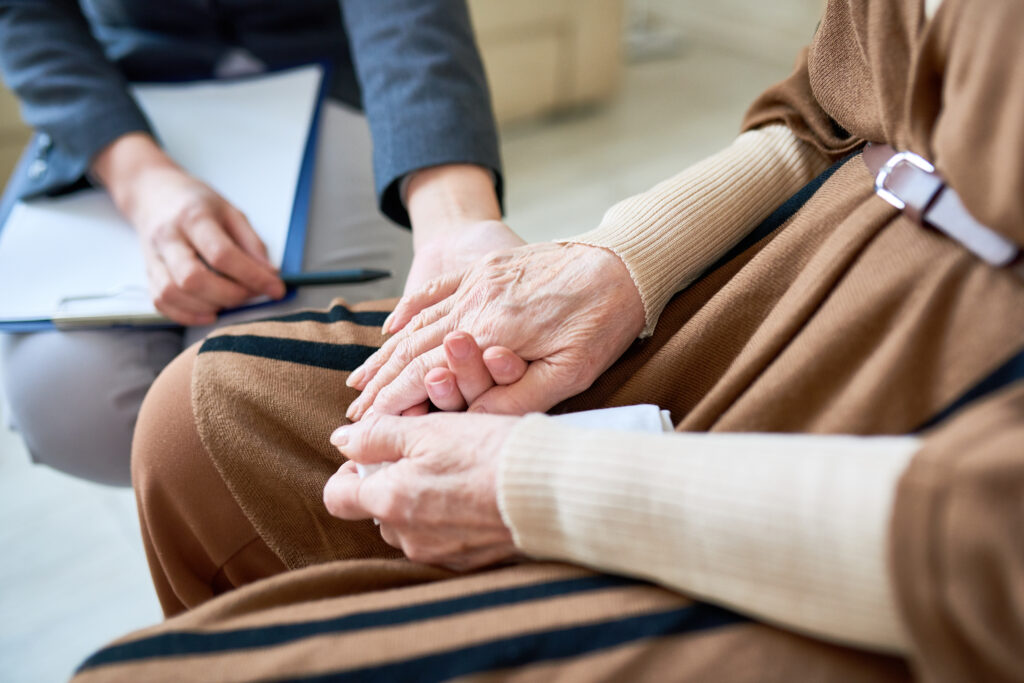 Close up of female Psychologist holding hand of senior patient