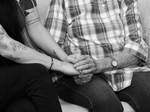Hospice nurse holding a patient's hand.